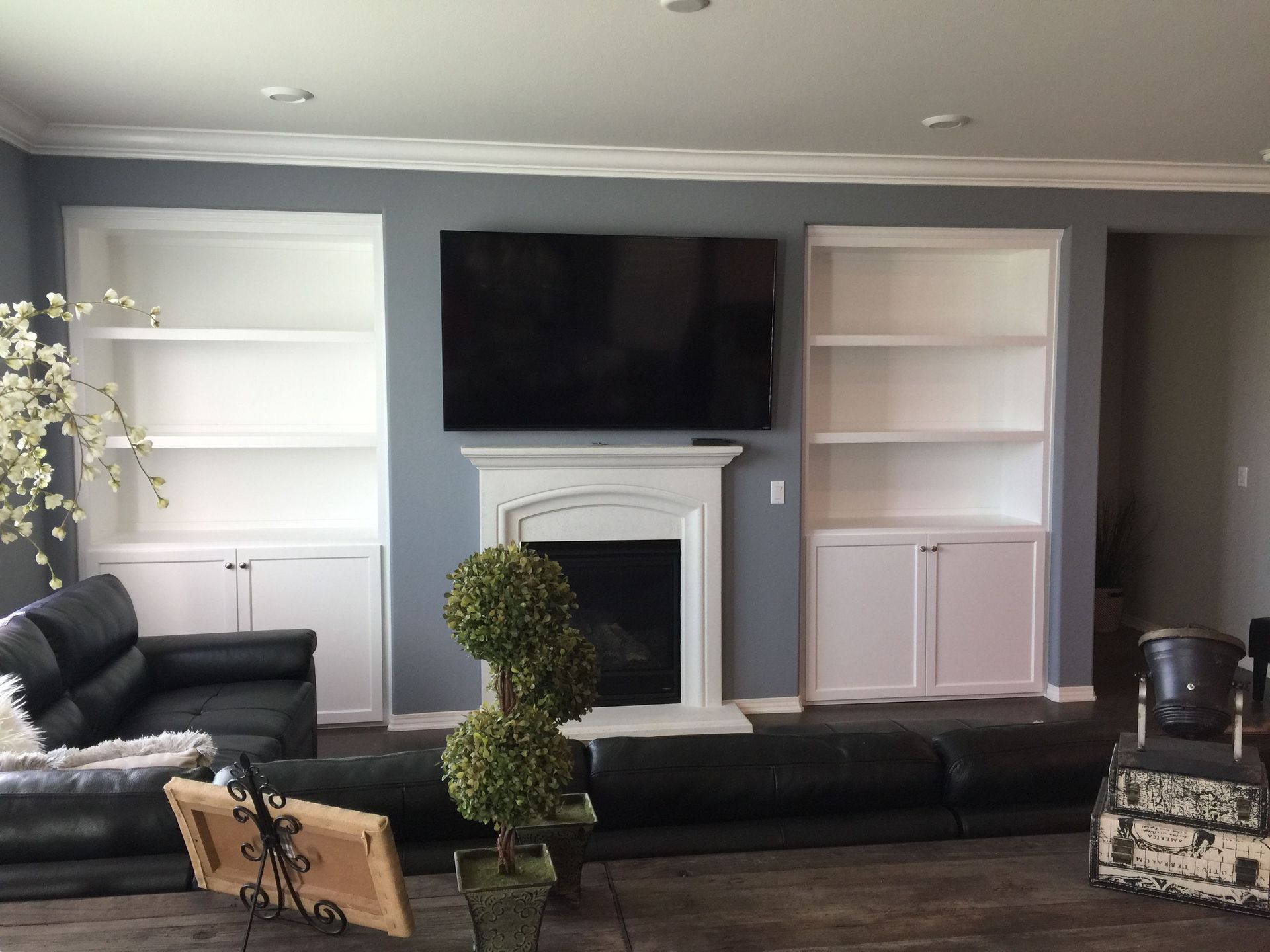 A living room with a fireplace , couch , television and shelves