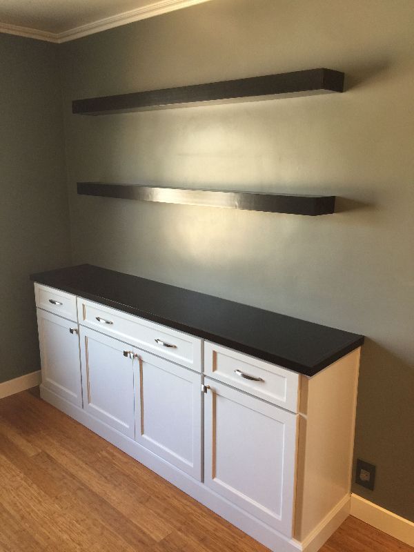 A room with white cabinets and black shelves