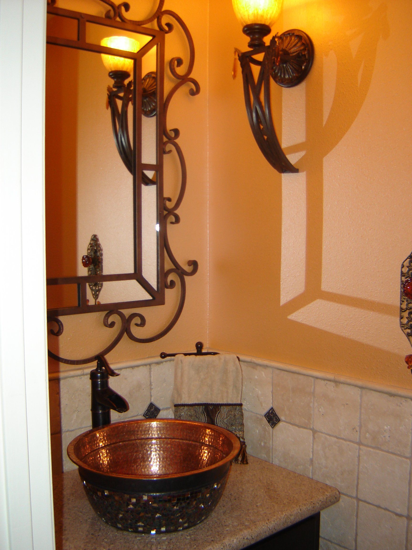 A bathroom with a copper sink and a mirror