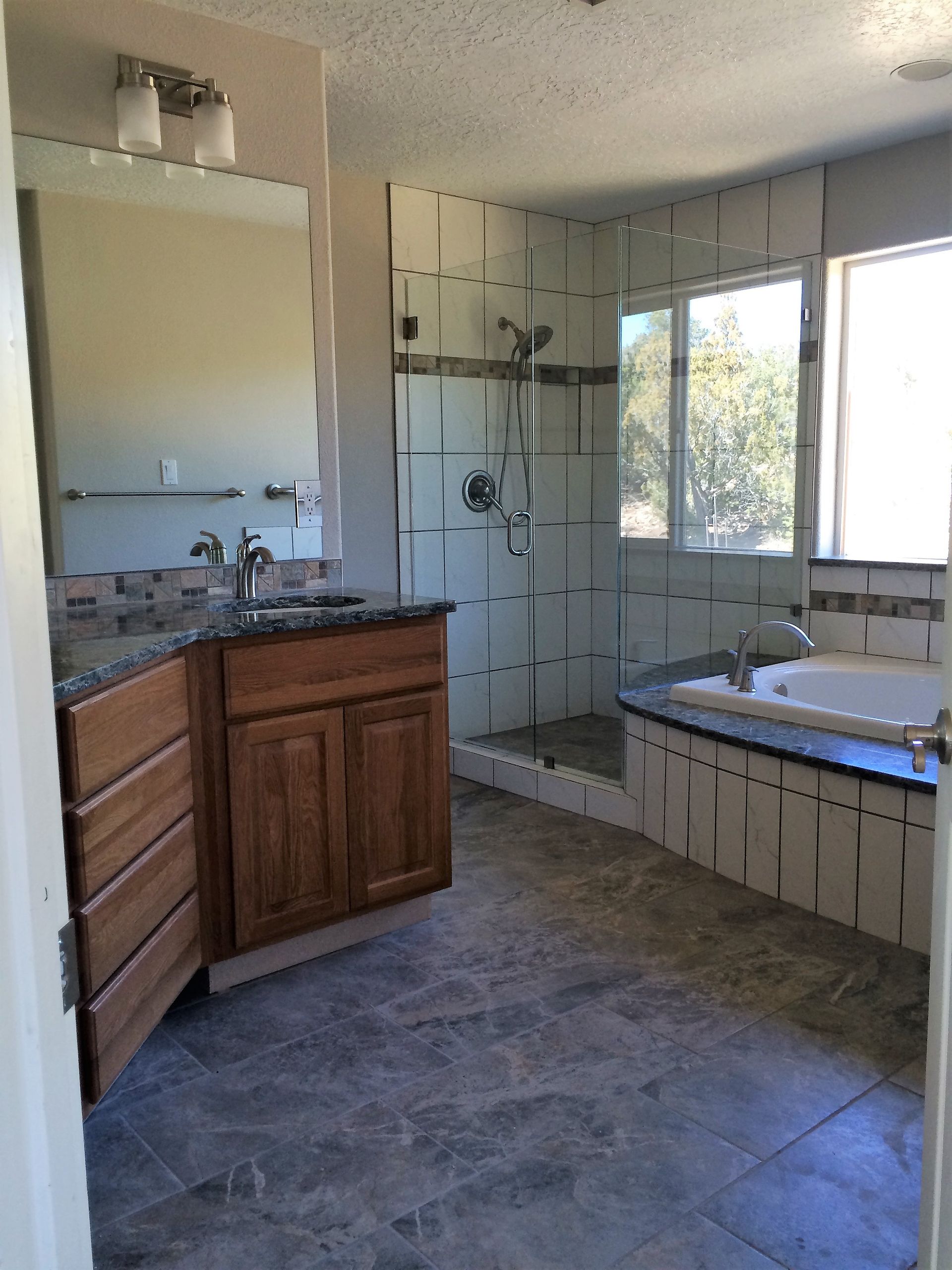 A bathroom with a sink , tub , shower and mirror
