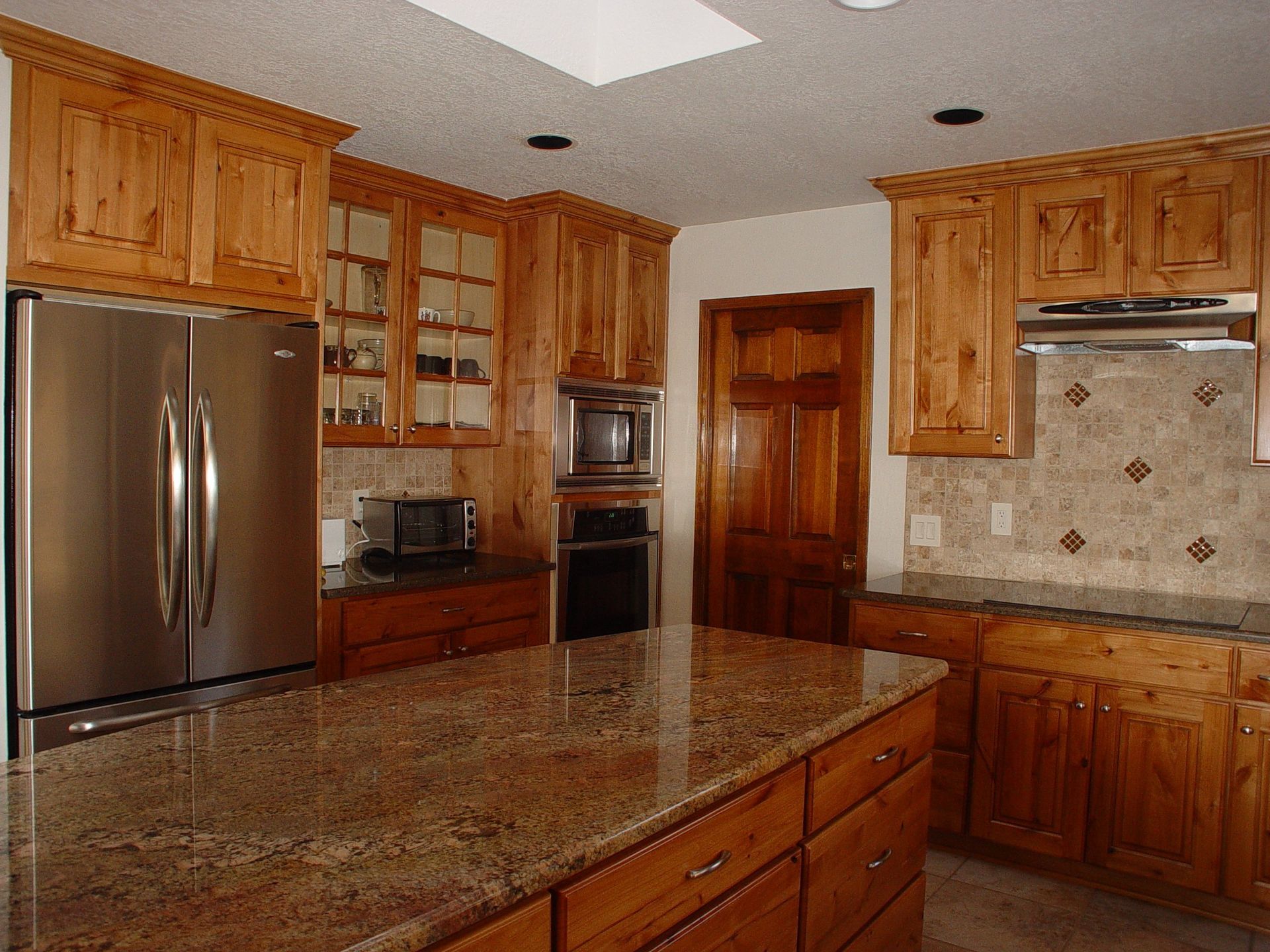 A kitchen with stainless steel appliances and wooden cabinets
