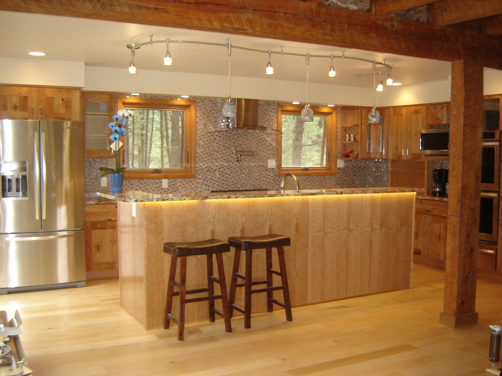A kitchen with a large island and two stools