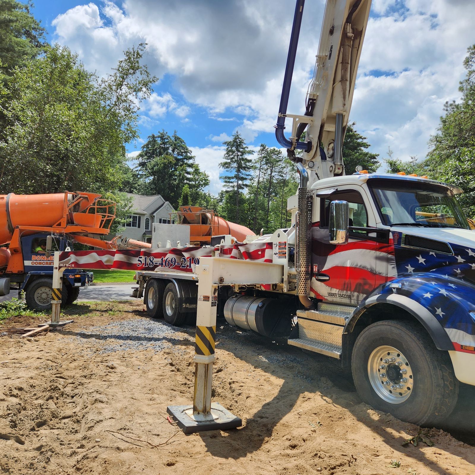 A concrete pump truck with an american flag painted on it