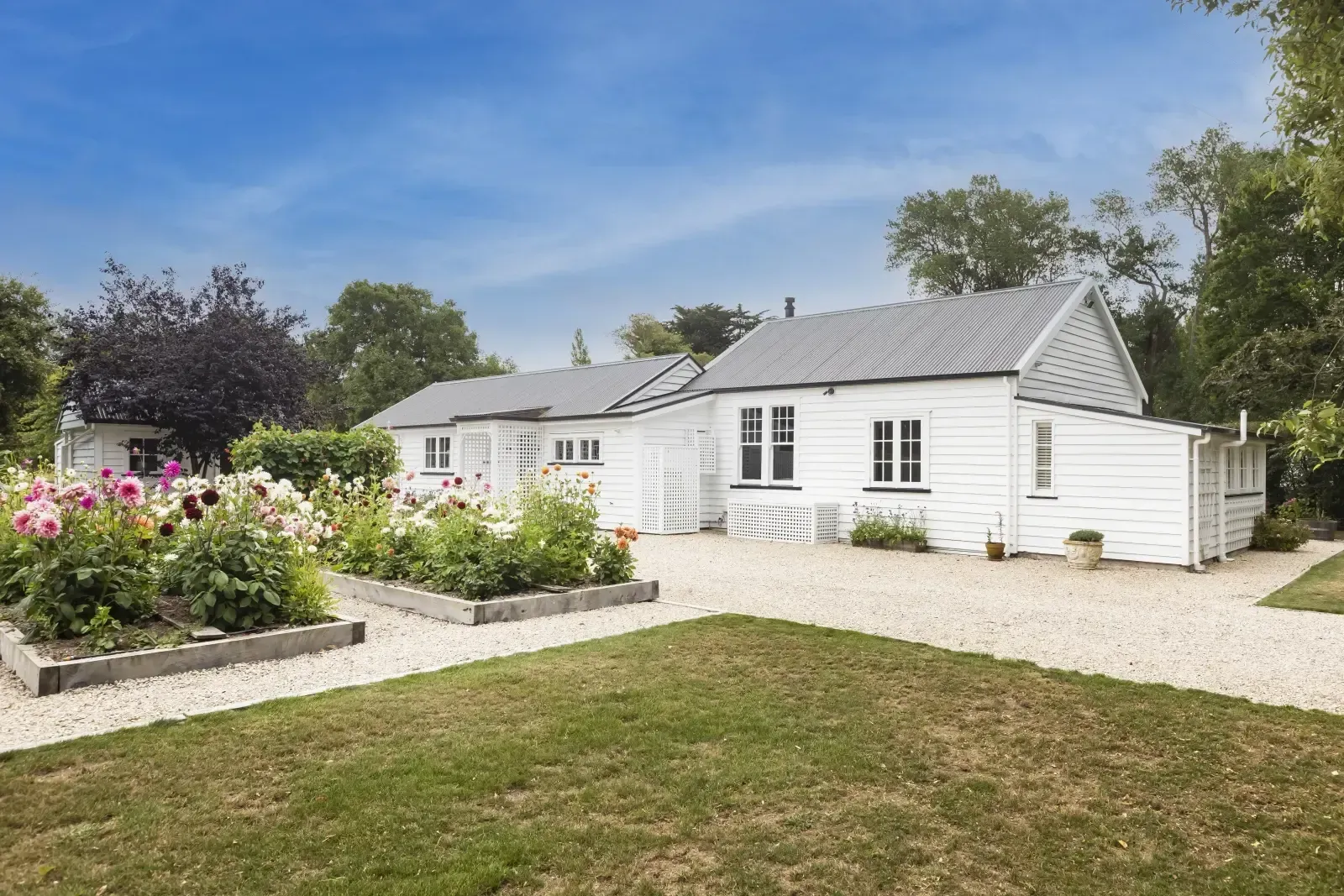 A large house sits in the middle of a lush green field