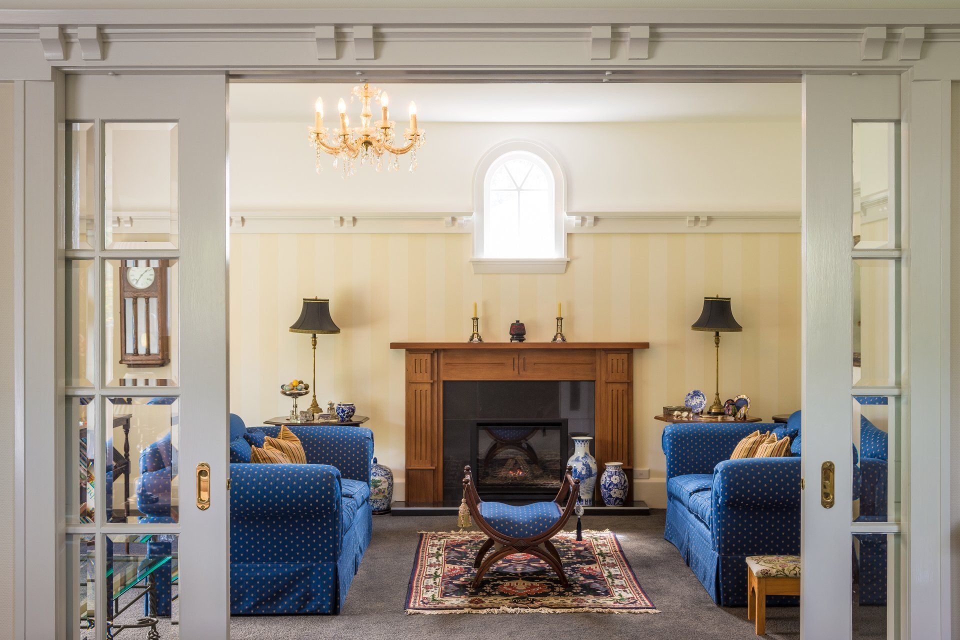 A living room with blue furniture and a fireplace
