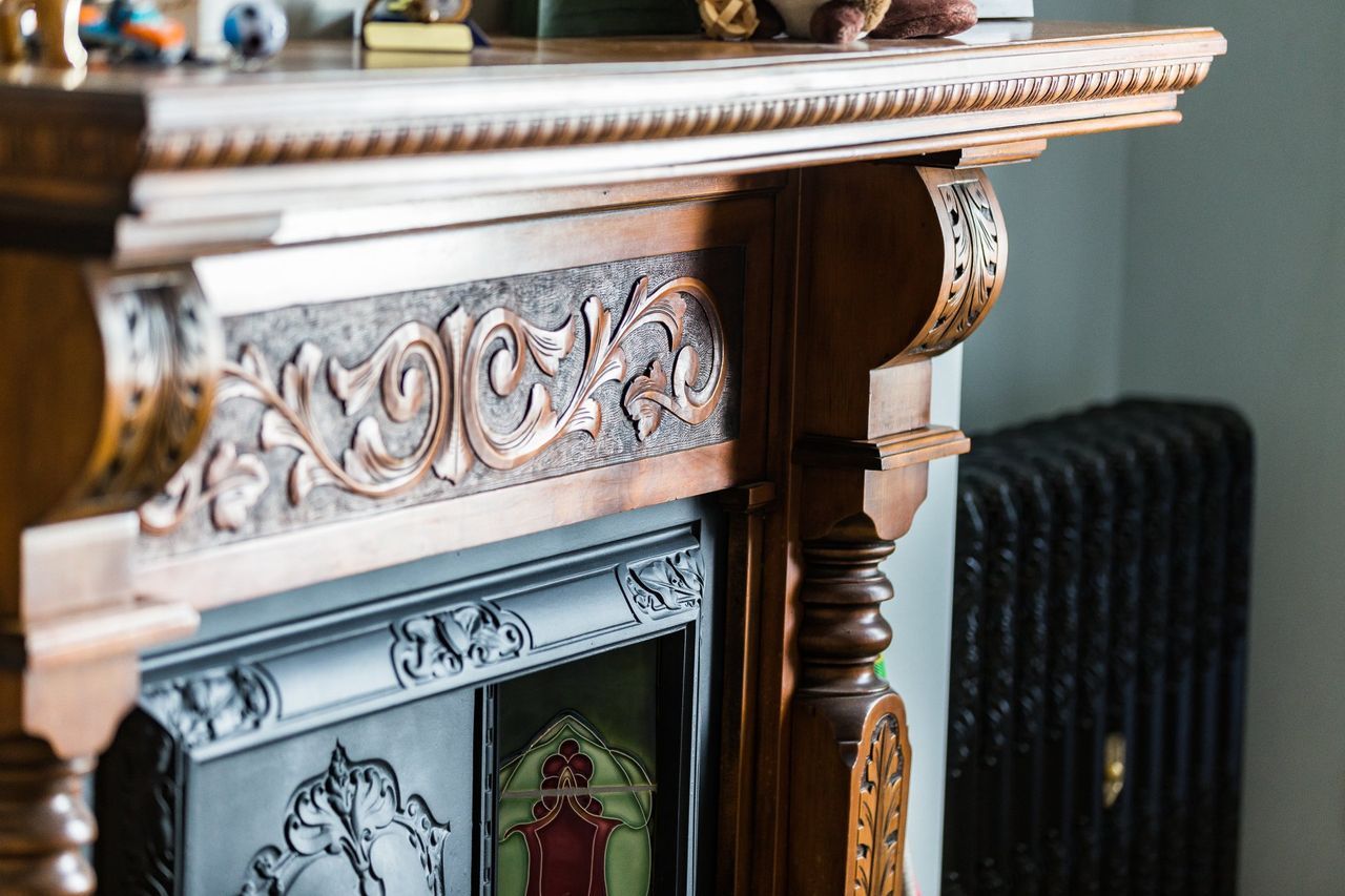 A fireplace with a clock on top of it in a living room.