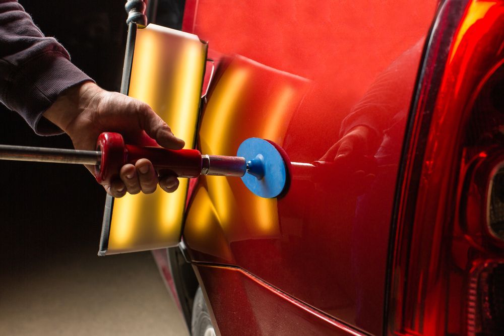 Hand Polishing a Red Car Door With a Buffer and Yellow Polishing Compound — Forster Smash Repairs in Forster, NSW