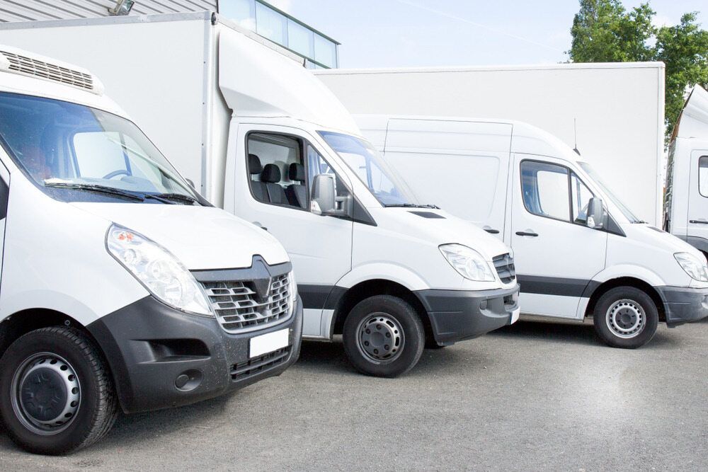 Three White Delivery Vans Parked Side by Side in an Industrial Lot — Forster Smash Repairs in Forster, NSW
