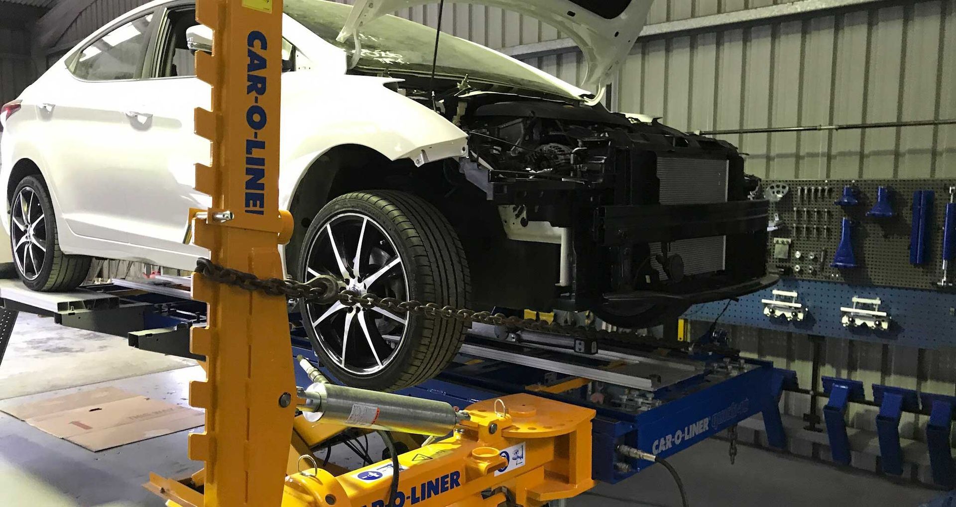 White Car on Automotive Lift in Repair Shop, Front End Partially Disassembled — Forster Smash Repairs in Forster, NSW