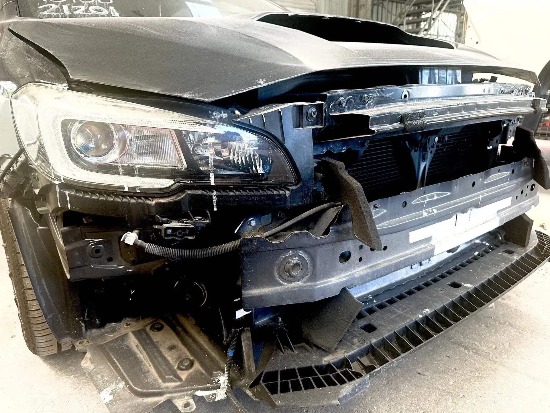 Front of a Black Car With Severe Collision Damage and a Crumpled Bumper — Forster Smash Repairs in Forster, NSW