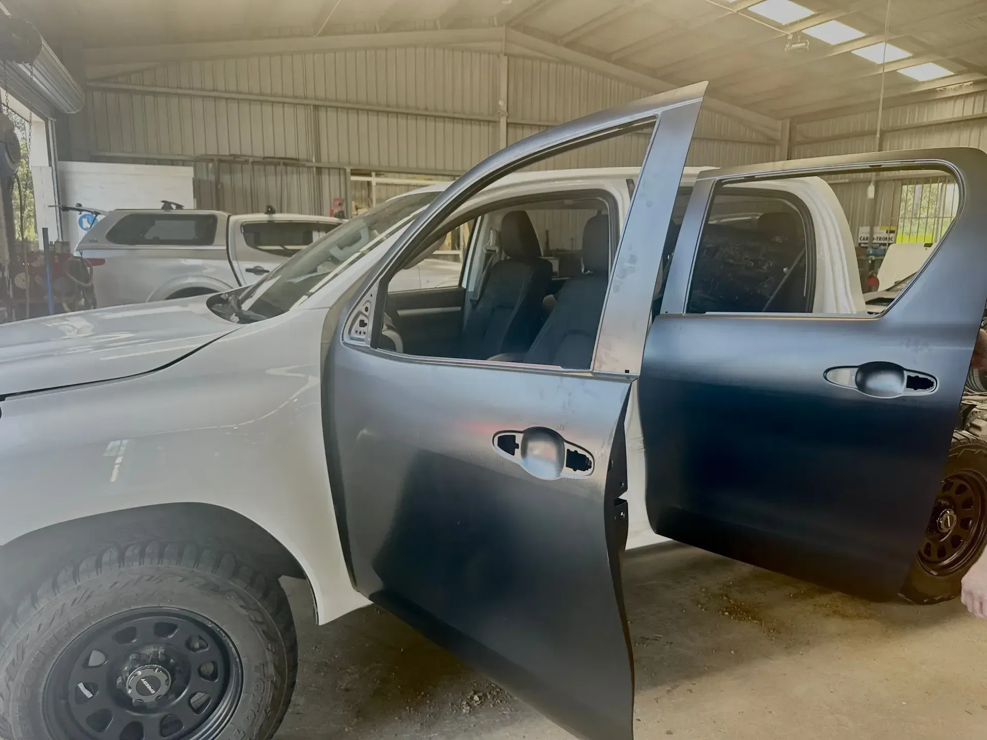 White Pickup Truck With Both Front Doors Open Inside a Workshop Garage — Forster Smash Repairs in Forster, NSW
