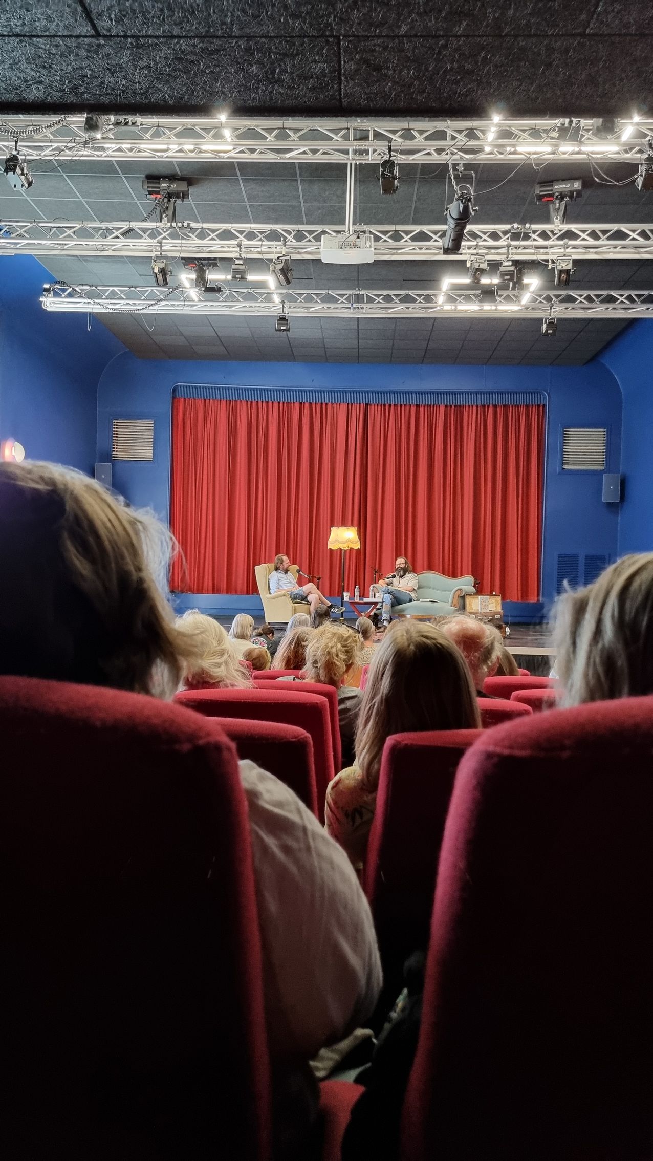 En gruppe mennesker sidder i et teater og ser en forestilling.