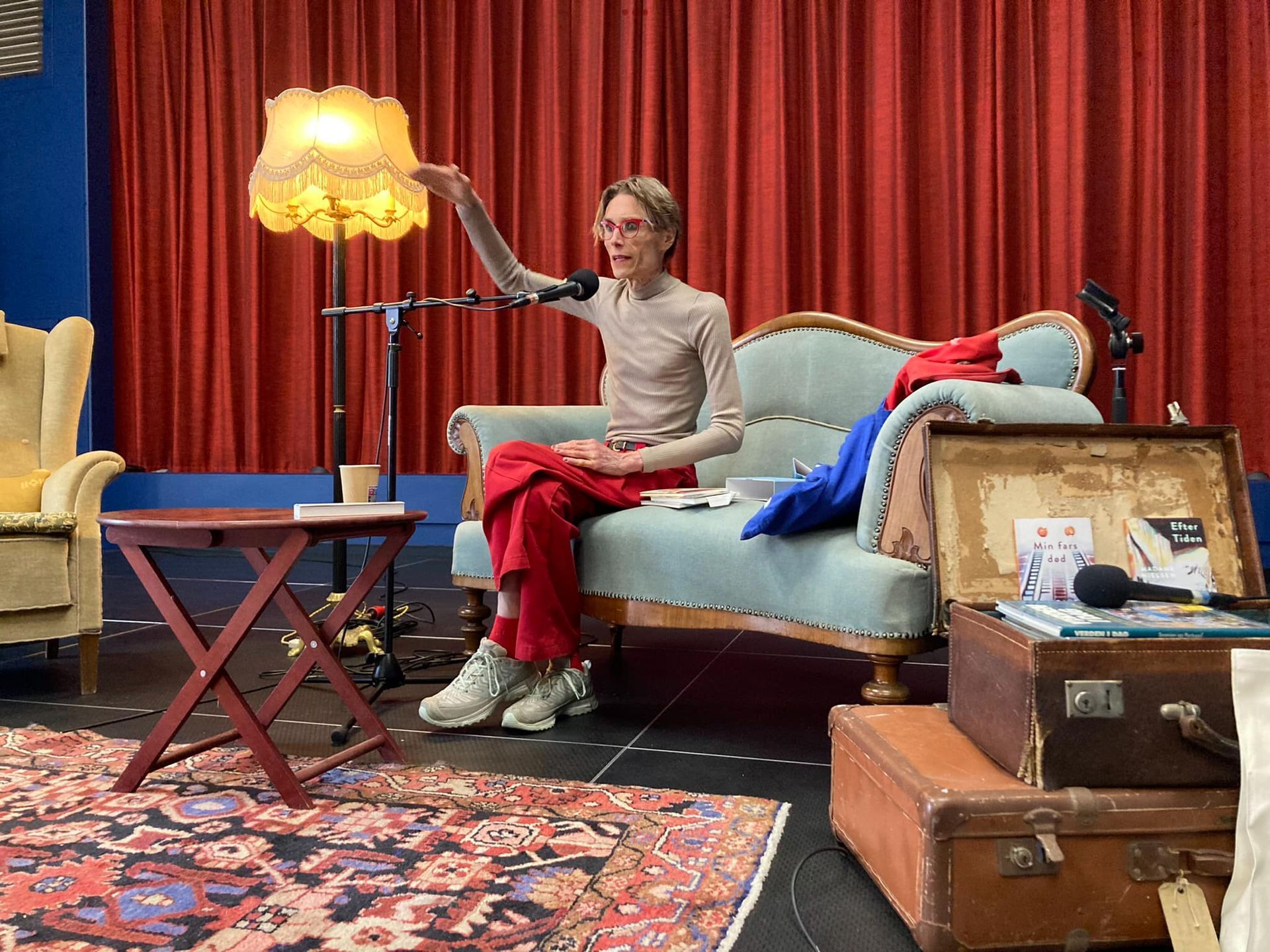 En mand sidder på en sofa foran en mikrofon.