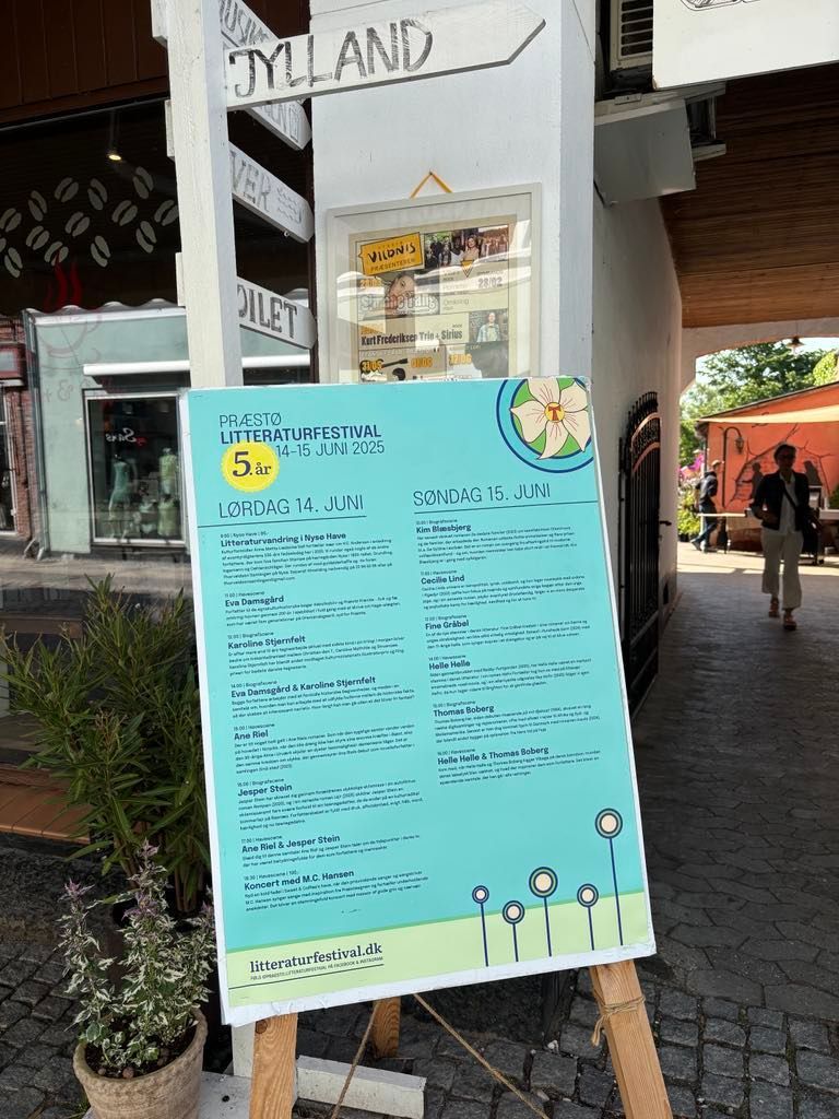 Et program vises på et træstaffeli uden for en bygning.