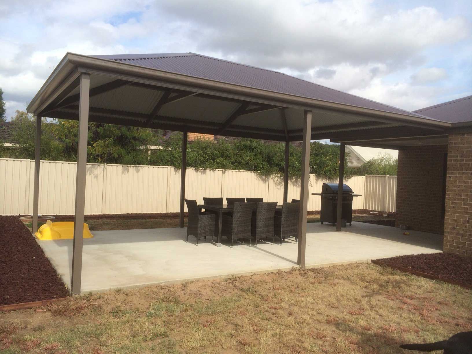 A Patio with a Table and Chairs Under a Canopy - Wallan, VIC - Victorian Garages & Barns