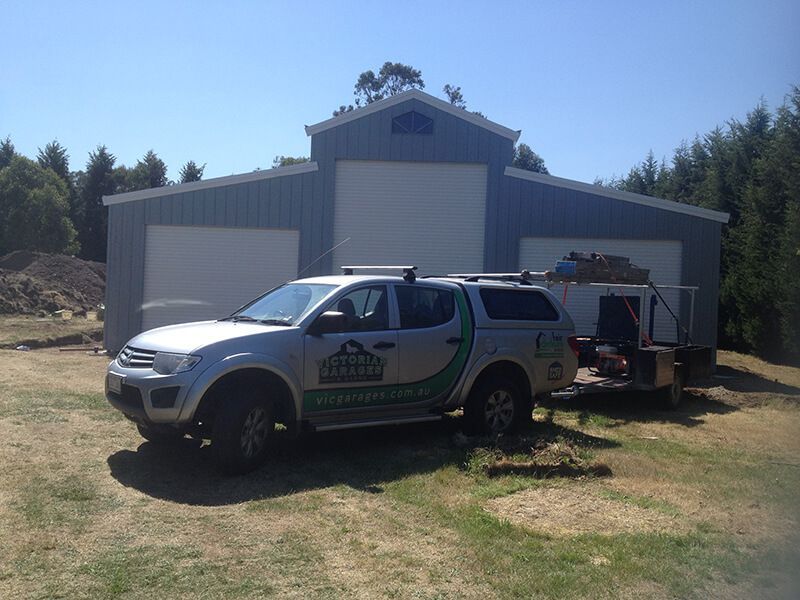 A White Truck is Parked in Front of a Building - Wallan, VIC - Victorian Garages & Barns