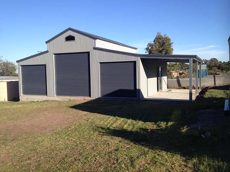 A Garage with Black Doors and a Porch - Wallan, VIC - Victorian Garages & Barns