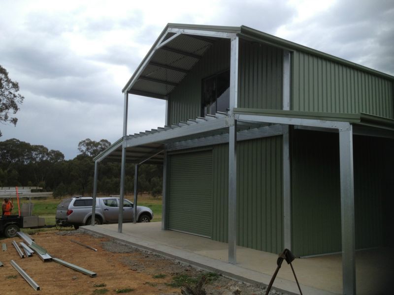 A Green Building with a Car Parked in Front of it - Wallan, VIC - Victorian Garages & Barns