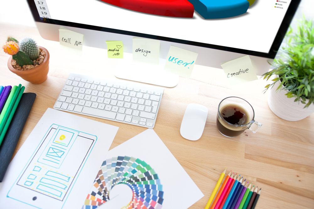 A desk with a computer , keyboard , mouse , pencils , and a cup of coffee.