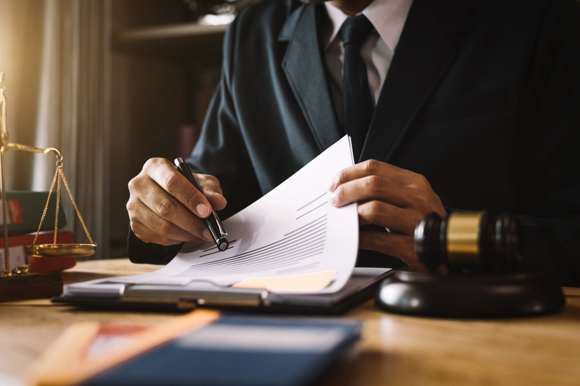 A lawyer is sitting at a desk writing on a piece of paper.