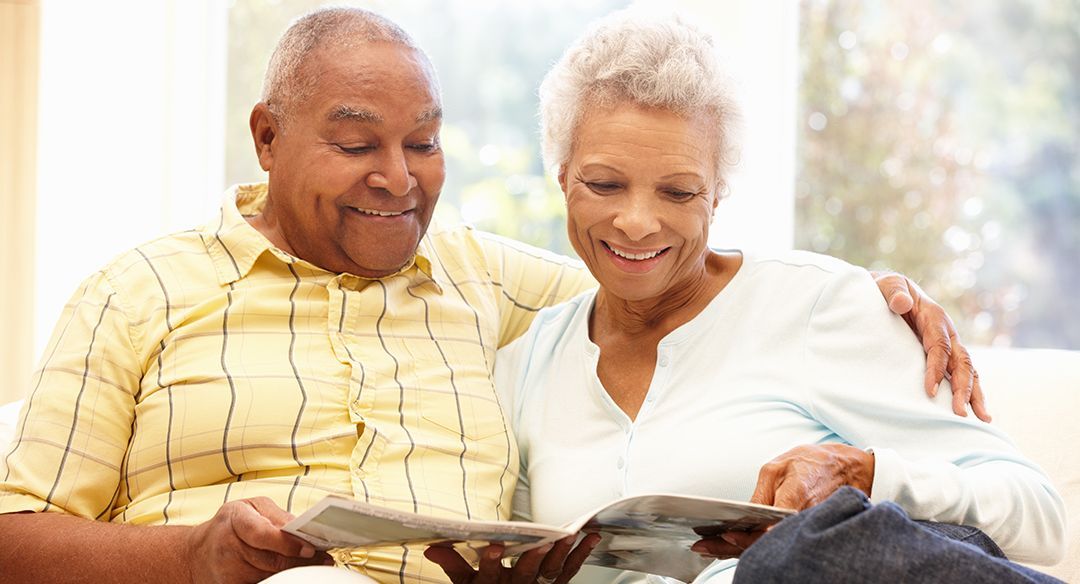 older couple sitting together reading a magazine