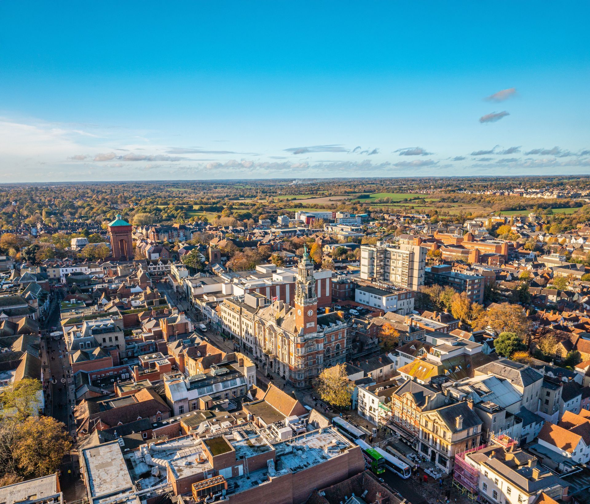 Aerial view of a historic city center with brick buildings and streets under a clear blue sky