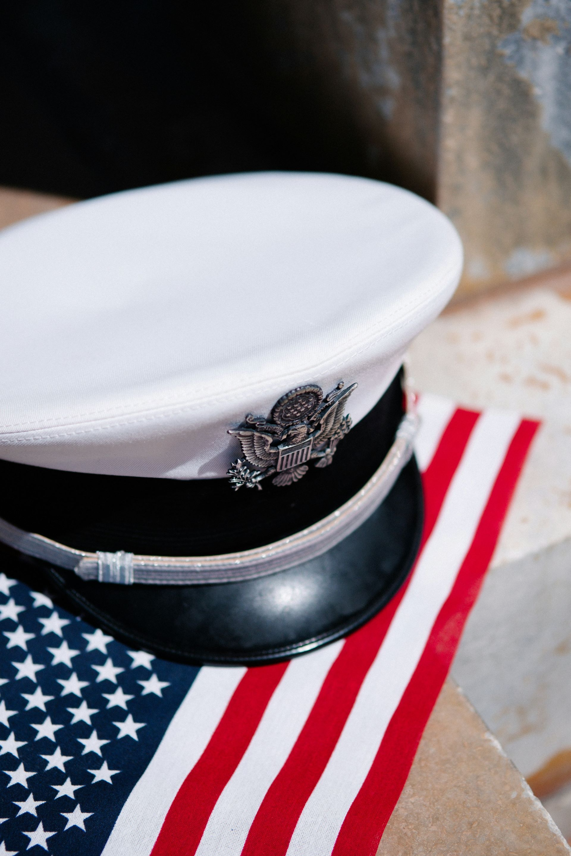 Military hat with crest on US flag.