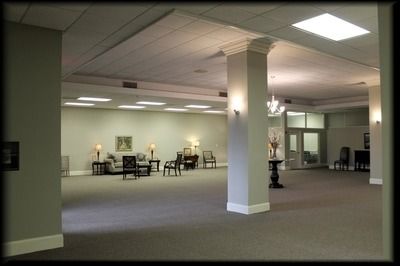 Interior of a large room with columns, chairs, and a small sitting area.