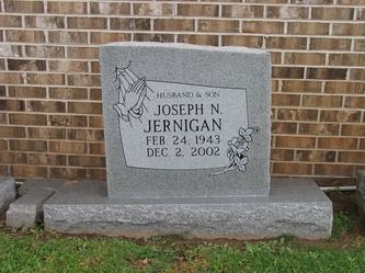 Headstone for Joseph N. Jernigan, with dates Feb. 24, 1943 - Dec. 2, 2002, set against a brick wall.