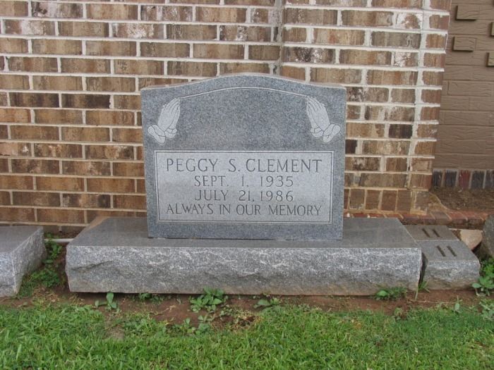 Headstone for Peggy S. Clement, engraved with dates Sept. 1, 1935 - July 21, 1966. Granite stone in front of a brick wall.
