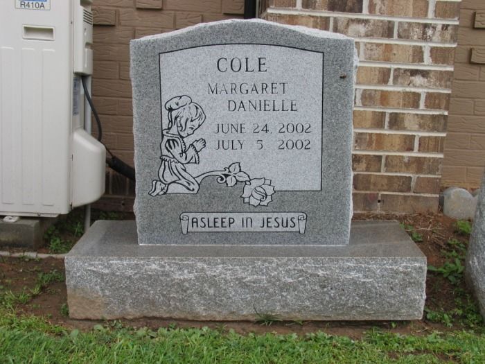 Gray headstone for Margaret Danielle Cole, with dates June 24, 2002 - July 5, 2002; includes a child praying and rose.