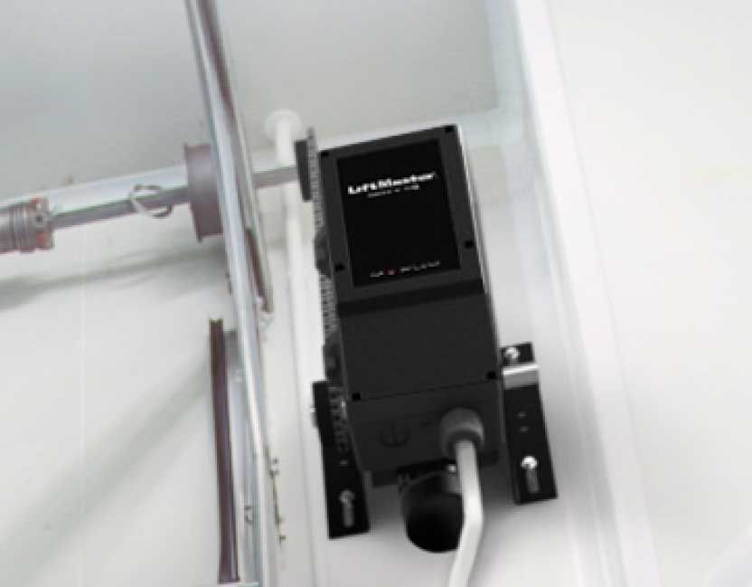 Garage door opener mounted on the ceiling, connected to the door track. Black and white, indoors.