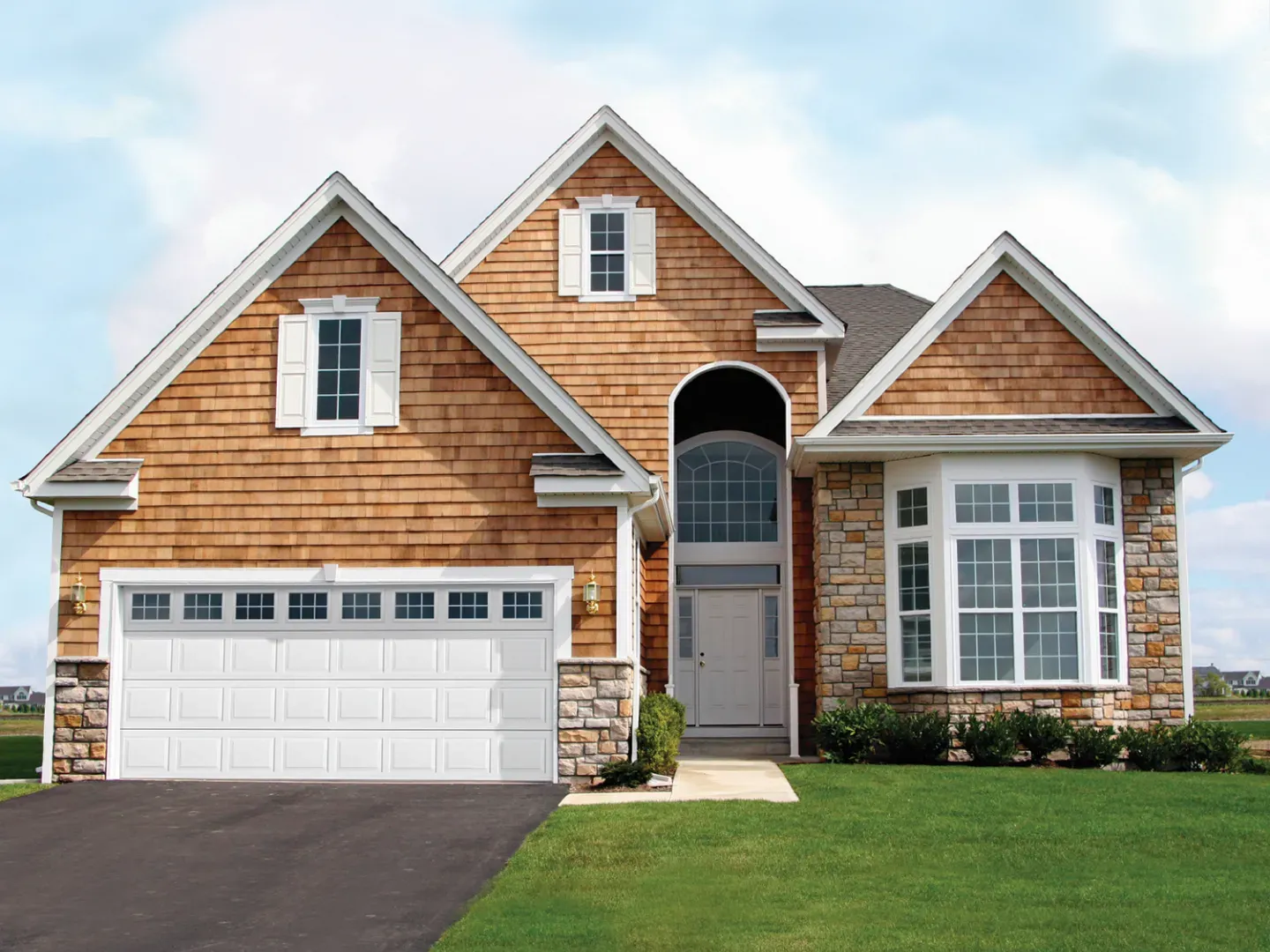 White garage with two doors, brick accents, and a white trellis above, with a gray shingled roof.