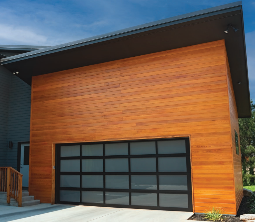 Modern garage with glass door, wood siding, and black trim.