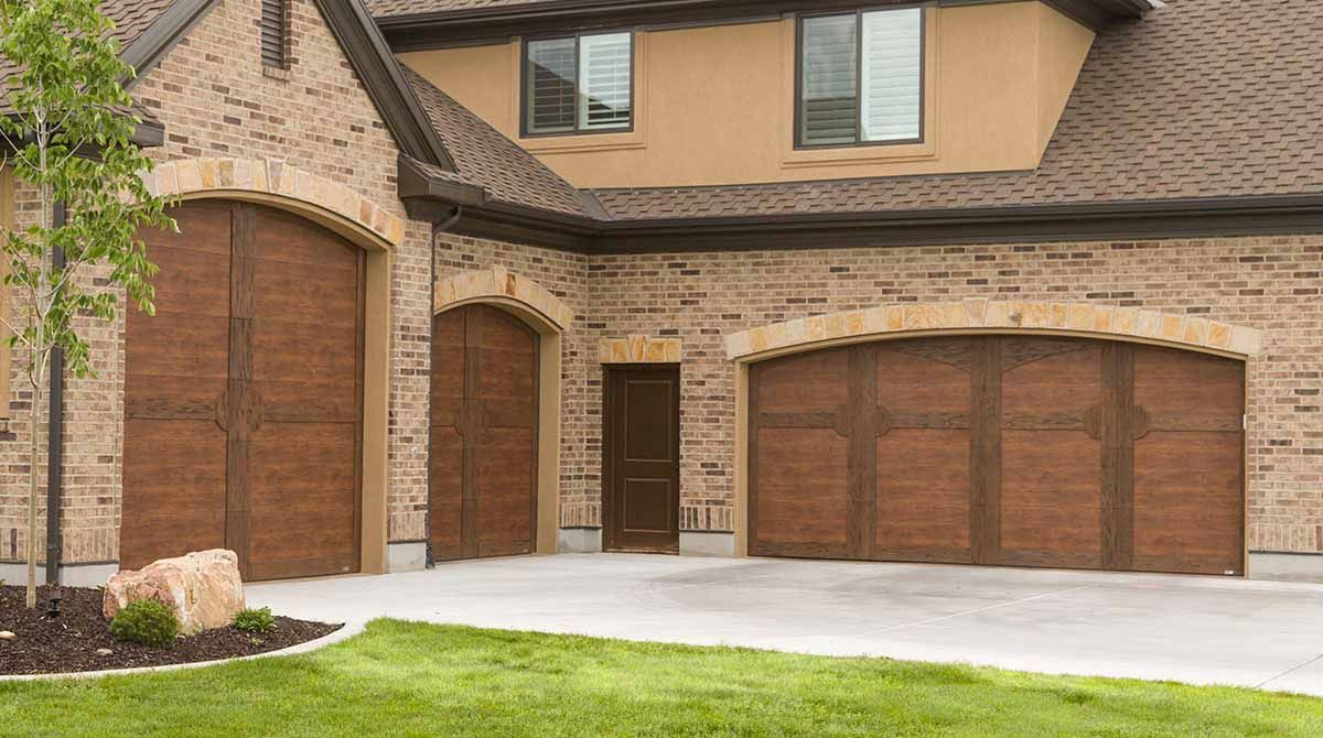 White garage door with windows in a brick building.