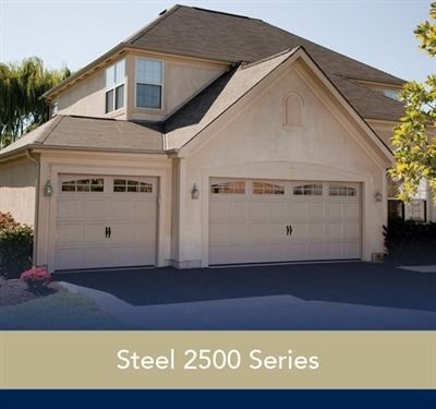 Modern building with three glass garage doors, wood and stone facade.