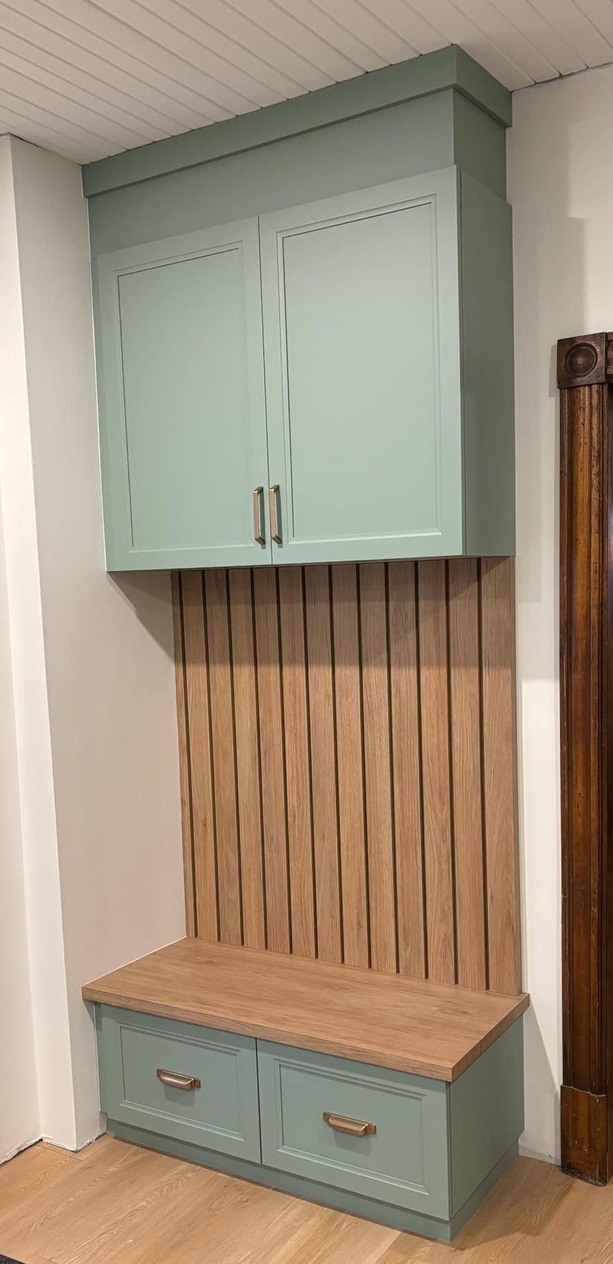 Une banquette intégrée avec un meuble de rangement au-dessus. Elle est peinte en bleu clair avec des éléments en bois.