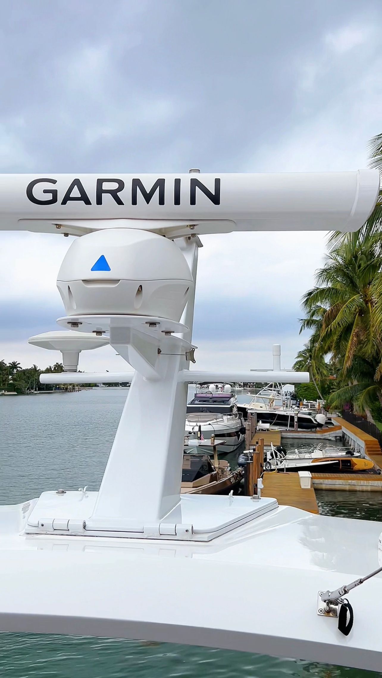 Garmin radar mounted on a boat deck overlooking water and a marina on a cloudy day