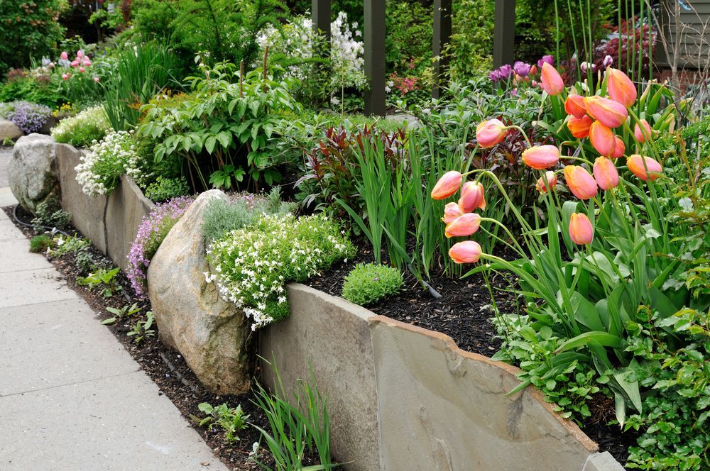 A Garden with Flowers and Rocks Along the Sidewalk — Greenline Recycling in Redland Bay, QLD