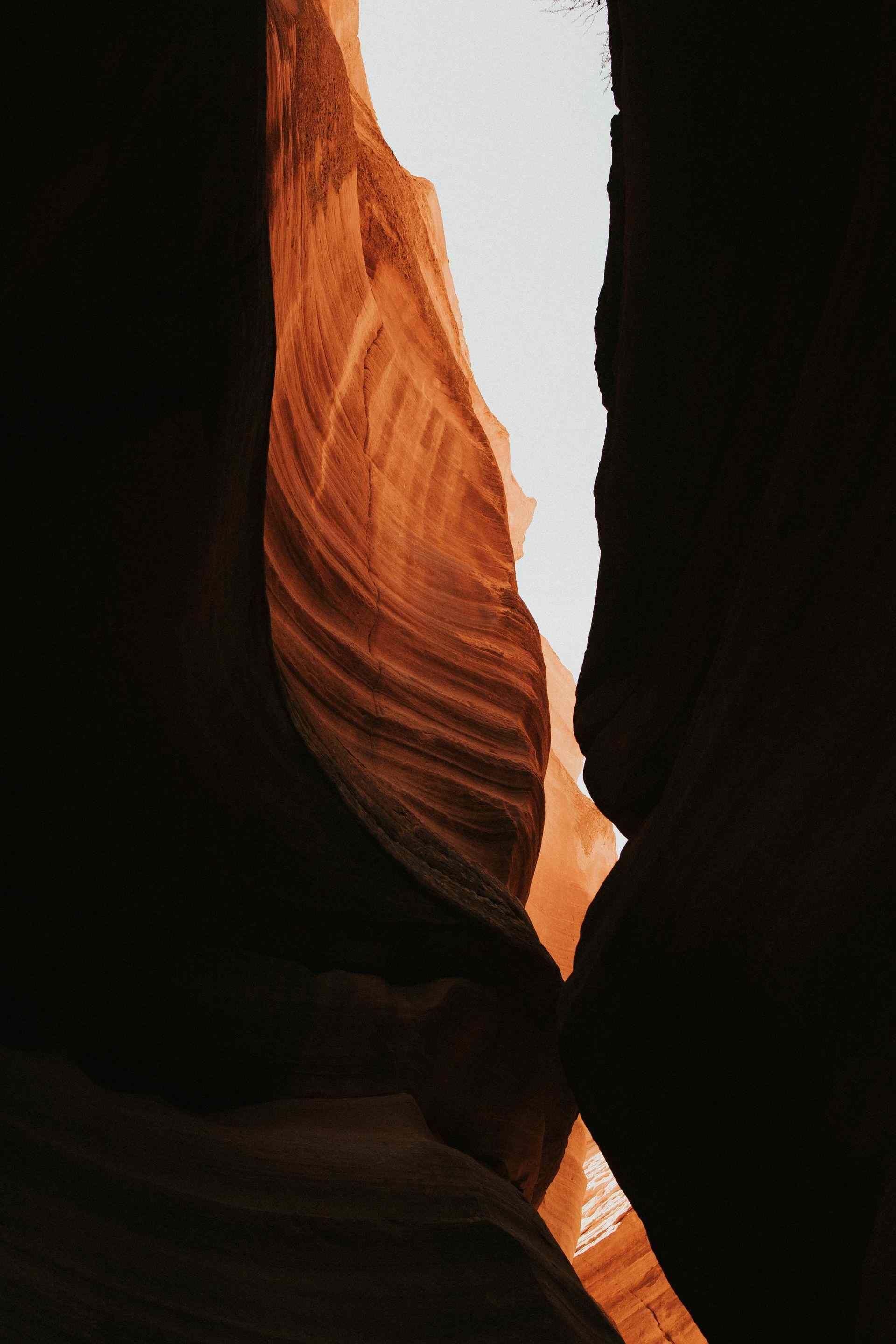 Narrow sandstone canyon with glowing orange rock walls and a sliver of sky overhead