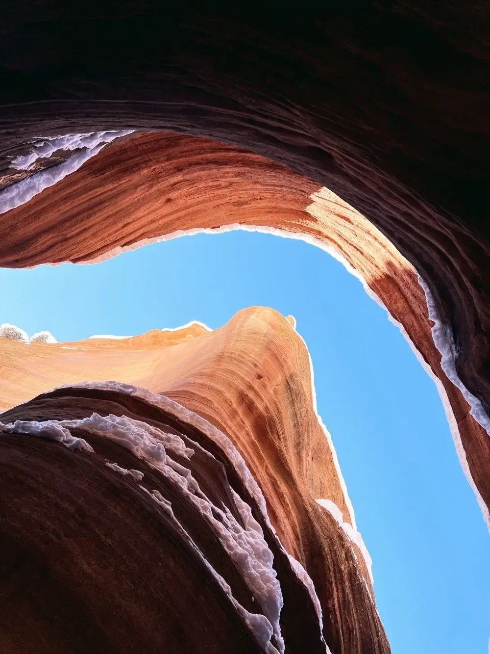 Looking up at a rock formation with a blue sky in the background
