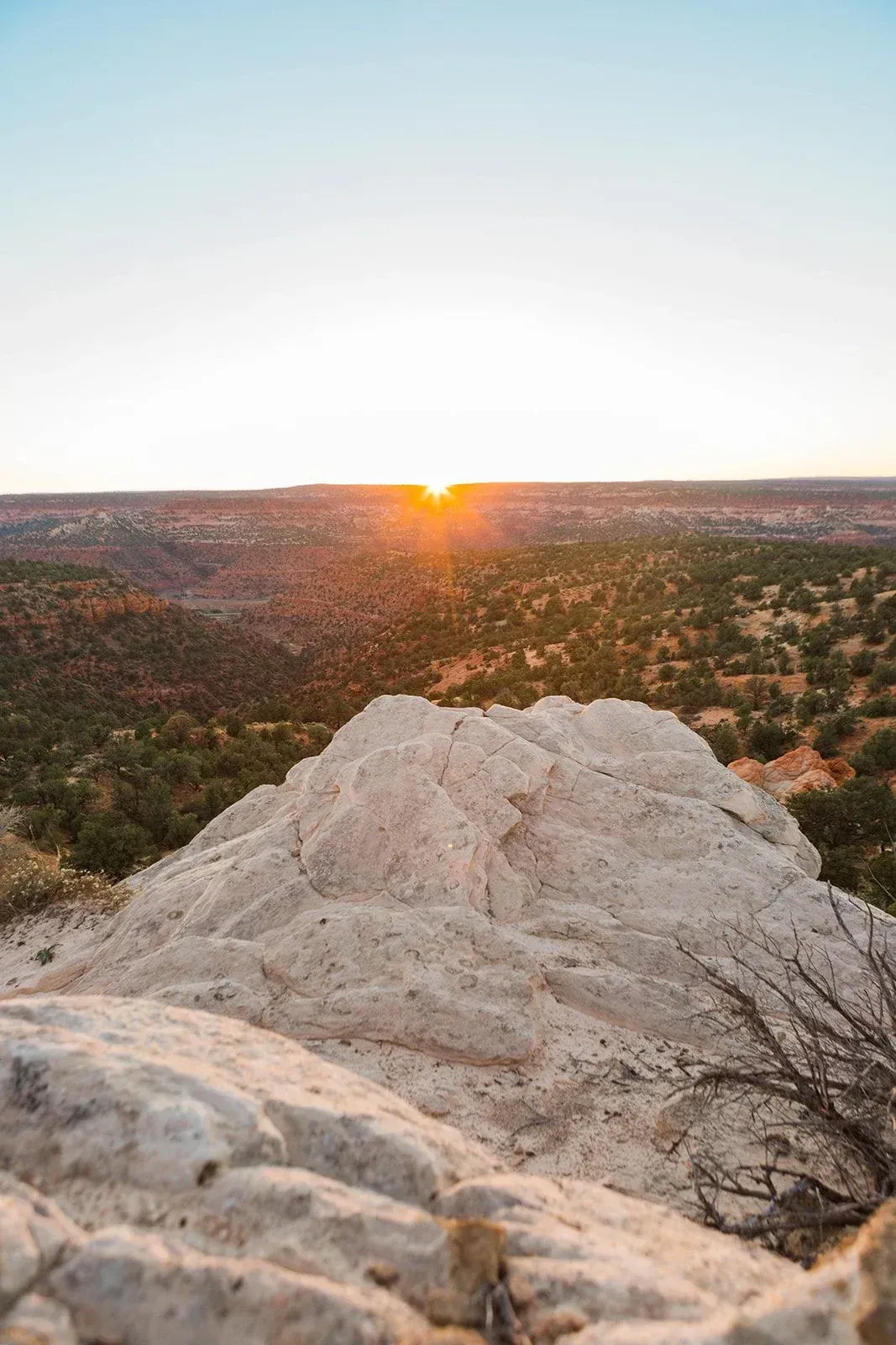 Sunset over a rocky desert landscape with white cliffs in the foreground
