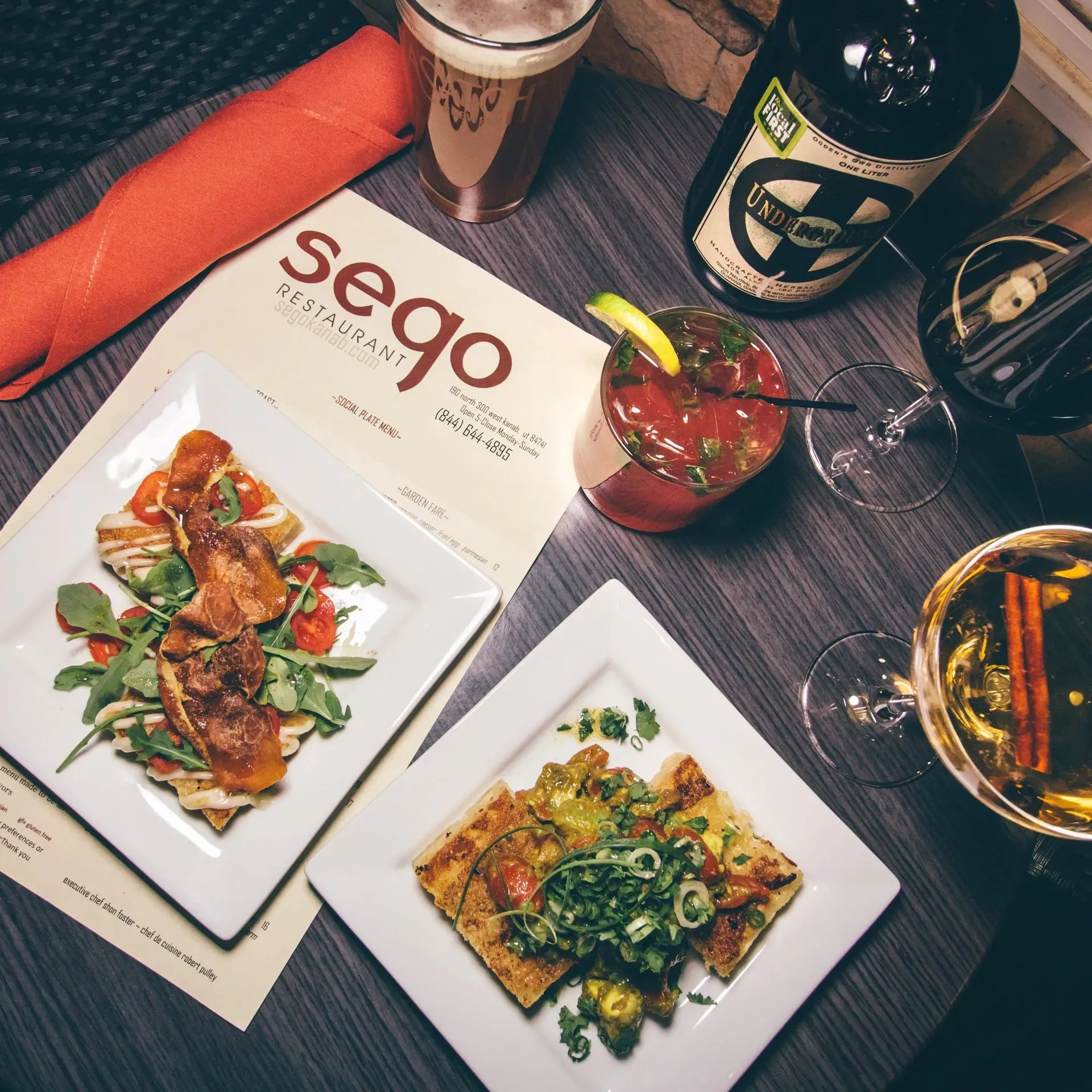 A table with plates of food and a menu for sego restaurant