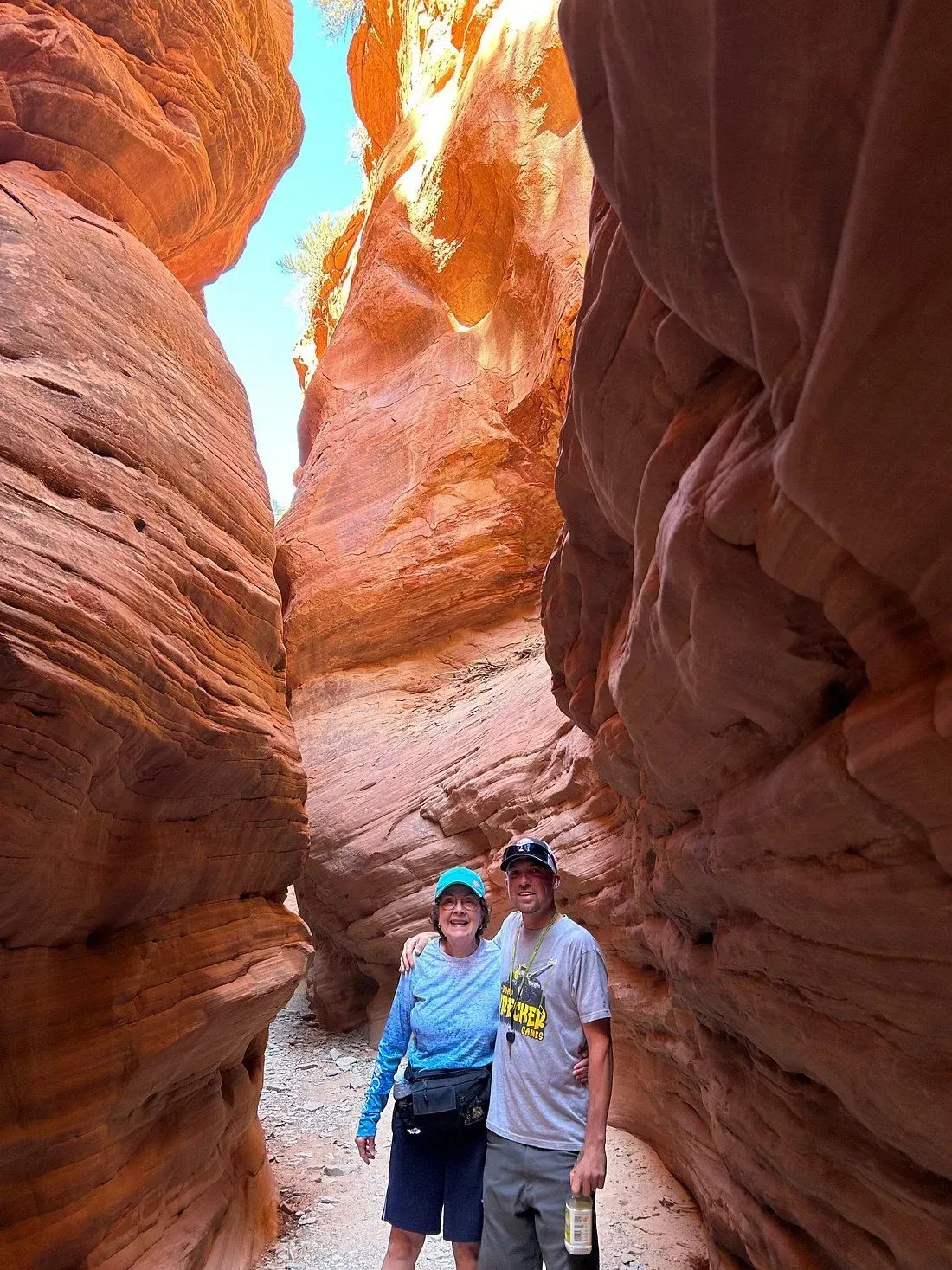 A man and a woman are standing in a canyon.