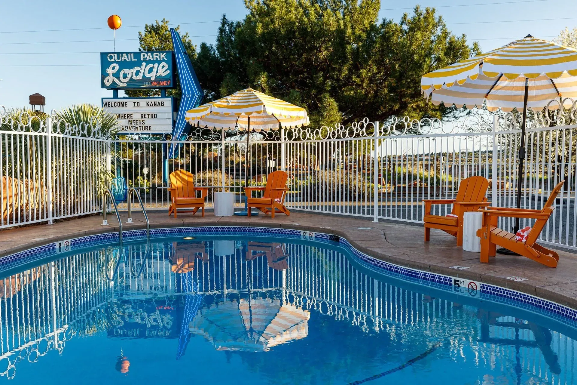 A large swimming pool with chairs and umbrellas around it.