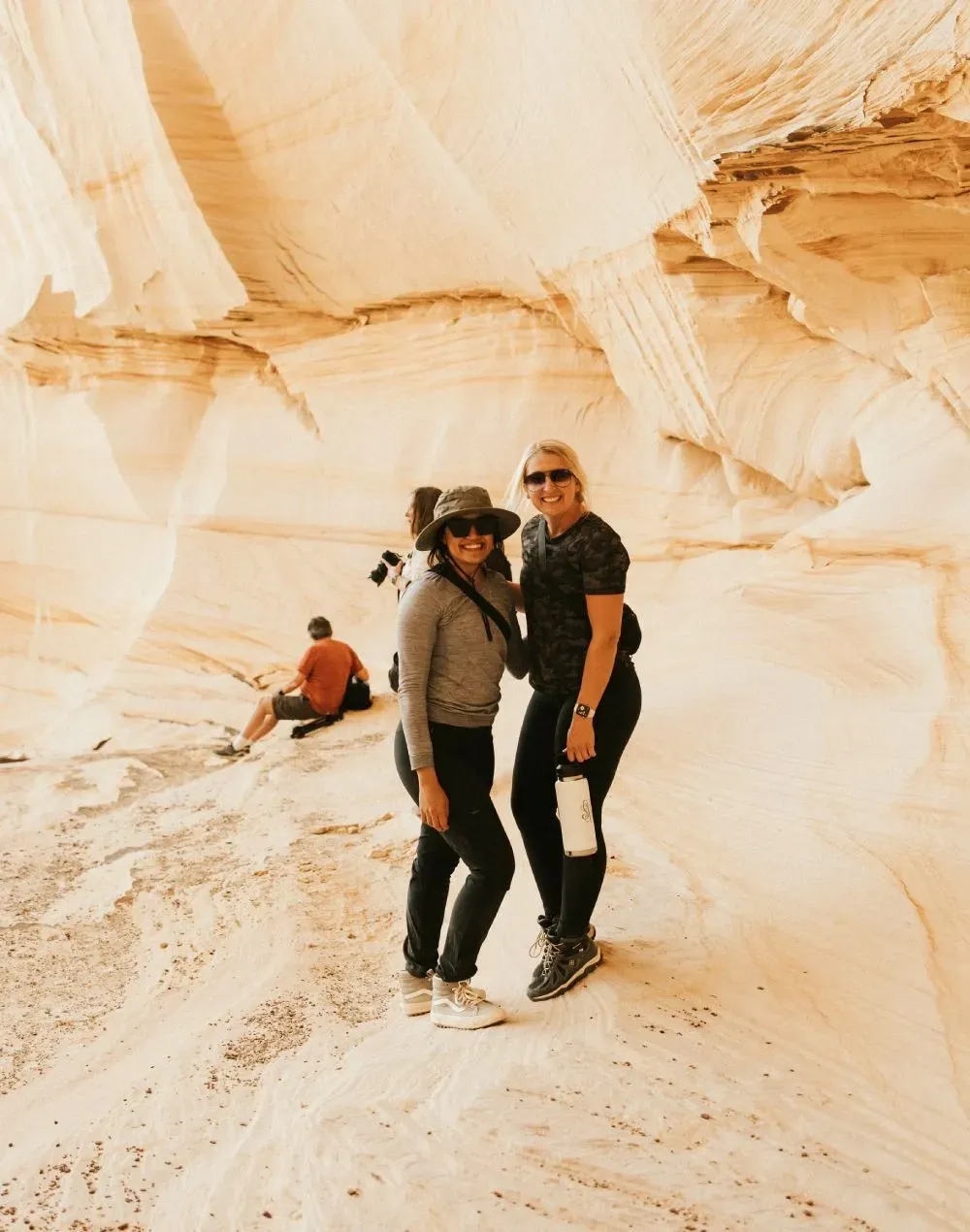 Two women are standing next to each other in the desert.
