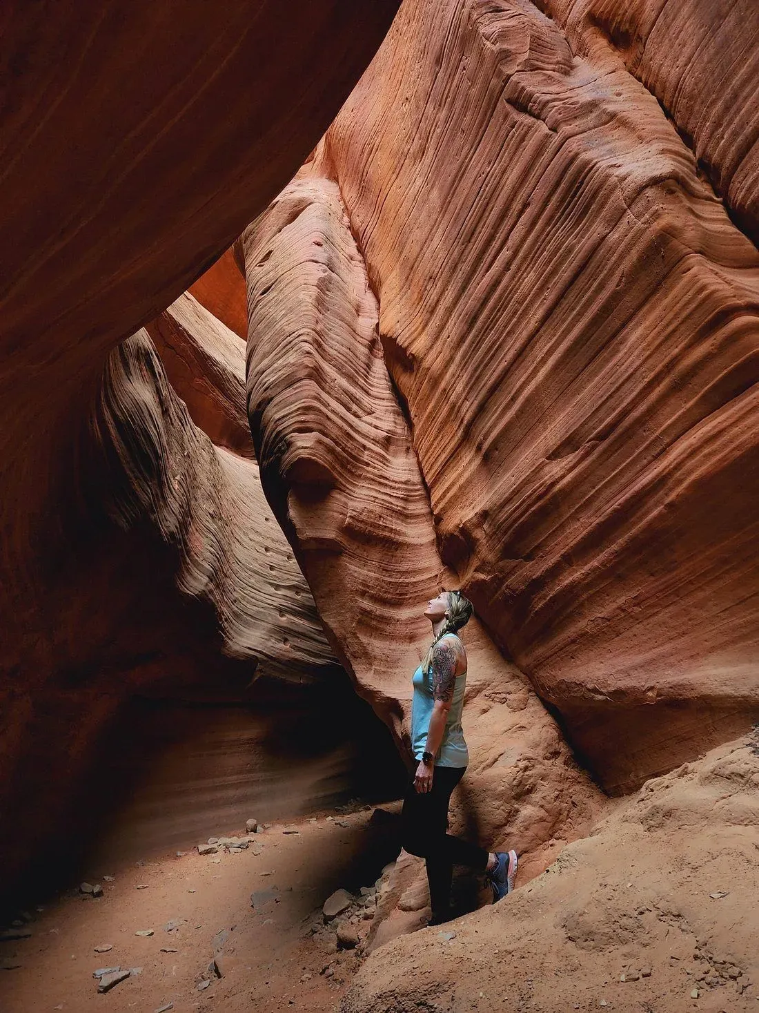 A woman is standing in the middle of a canyon.