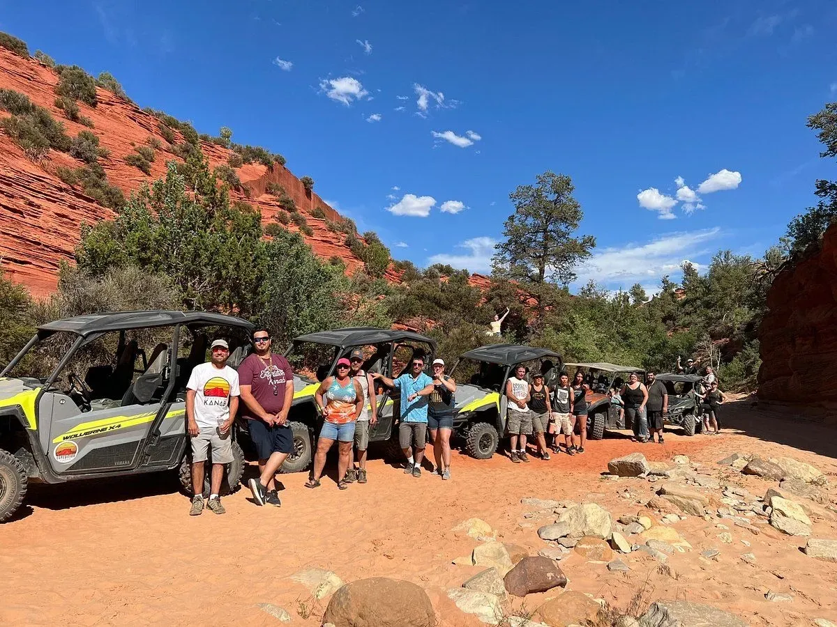 A group of people are standing in front of a row of atvs.