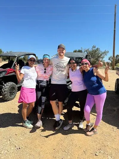A group of people are posing for a picture in front of a atv.