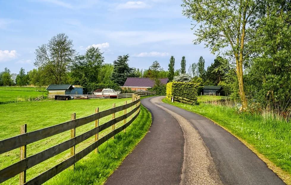 A Country Road With A Wooden Fence Going Through A Grassy Field — Northstar Excavations In Alstonville, NSW